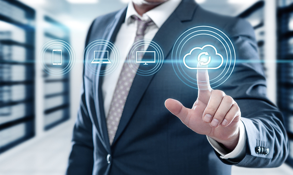 Man in business suit pointing to a cloud graphic.